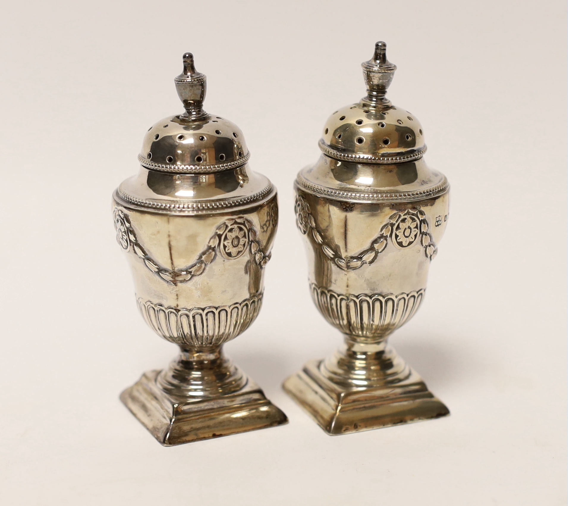 A pair of Victorian silver urn shaped pedestal pepperettes, Henry Wilkinson & Co Ltd, Sheffield, 1880, 83mm.